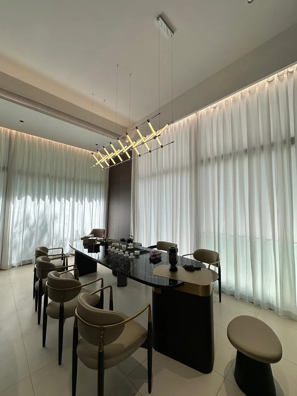 Assembled dining table and chairs beside full-height curtains