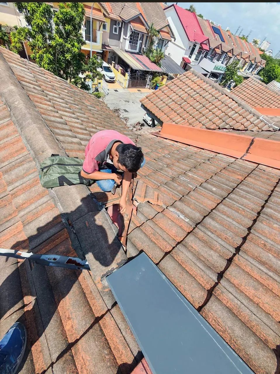 Handyman working carefully on tiled roofing