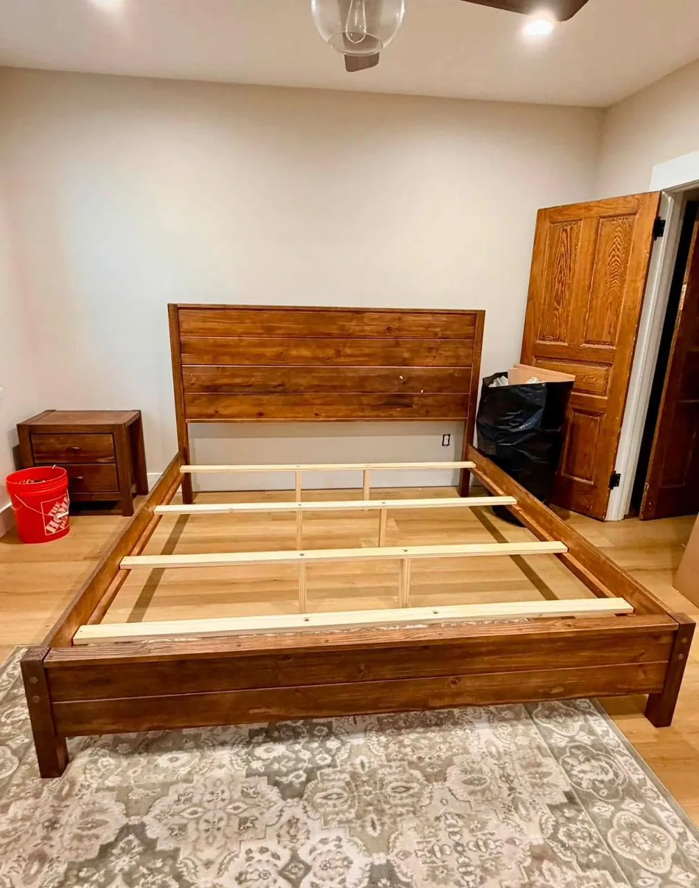 Completed wooden bed frame assembled in a bedroom